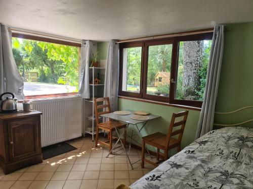 une chambre avec une table, des chaises et un lit dans l'établissement Chambre à la ferme, les vergers du Muscardin, à Bréel