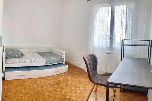 a bedroom with a bed and a chair and a table at Appartement bien situé in Noisy-le-Grand