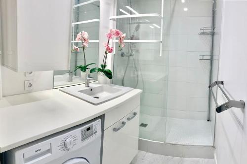 a white bathroom with a sink and a shower at Appartement bien situé in Noisy-le-Grand