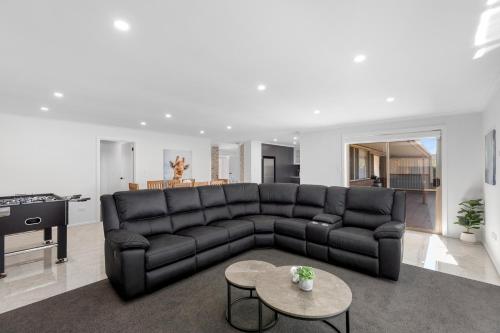 a living room with a black couch and a table at Heinlen on North Terrace in Mount Gambier