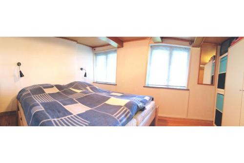 uma cama num quarto com duas janelas em Stony em Brösarp