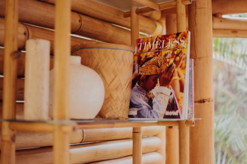 a magazine sitting on a shelf next to a book at Hideout Eco Bamboo House Bali in Selat