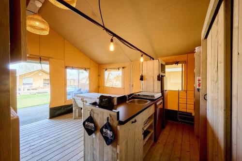 a kitchen with a sink and a stove in a house at Glamping Ackersate in Voorthuizen
