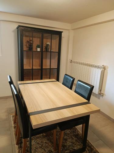 drewniany stół i krzesła w pokoju w obiekcie Paisible appartement proche des 24h et du lac w mieście Arnage