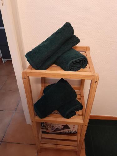 ein Handtuchhalter aus Holz mit schwarzen Handtüchern darauf in der Unterkunft appartement city 2 d'Amiens in Amiens