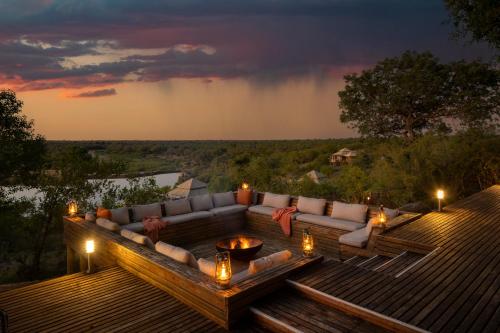 a deck with a couch and a table with lights at Simbavati Hilltop Lodge in Timbavati Game Reserve