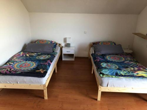 two beds in a small room with at Schöne Ferienwohnung im Voralpenland in Pfaffing