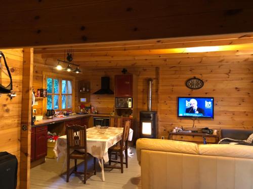 a kitchen and living room with a table and a television at Maison Bois in Laruns
