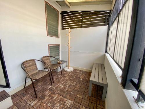 a small balcony with two chairs and a table at Yaksa Private in Bangkok