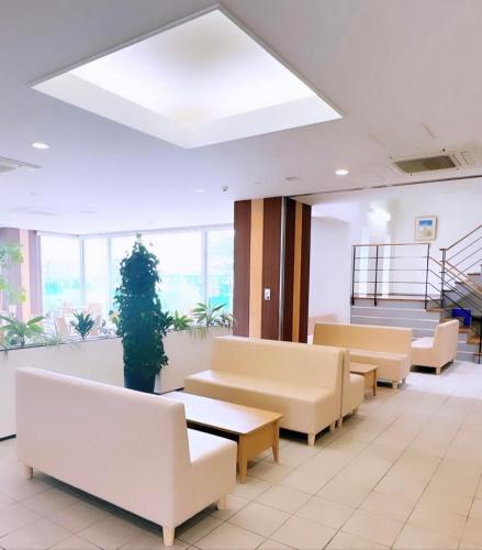 uma sala de espera com sofás e mesas num edifício em ホテル辰巳俱楽部 