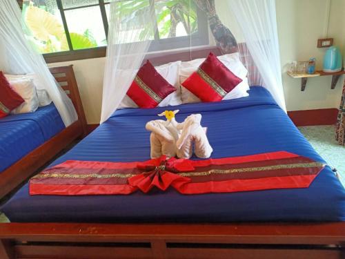 two stuffed animals are sitting on a bed at Khao Sok River & Jungle Bungalow in Khao Sok