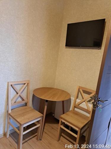 um quarto com duas cadeiras e uma mesa e uma televisão em Davit batoni Guest house em Mtskheta