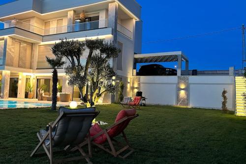 a house with two lawn chairs in the yard at Villa safkan in Silivri