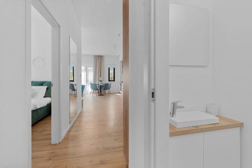 - une salle de bains blanche avec lavabo et une chambre dans l'établissement Darwin Apartments, à Otopeni