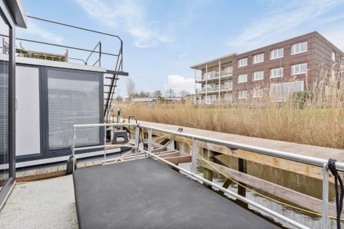 a building with a ramp with a building in the background at Luxurious waterloft near beach and centre by Weltevreden Experience in Zeewolde