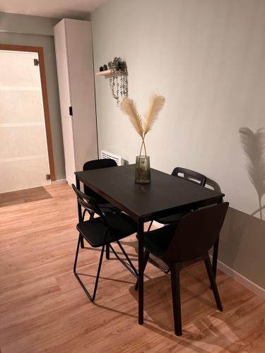 a dining room with a black table and chairs at Studio MANI in Ostend