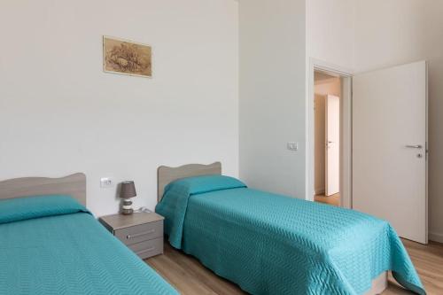 1 dormitorio con 2 camas y sábanas azules en monji apartment en Faenza