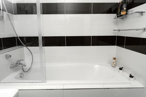 a white bathroom with a shower and a tub at BNB New Beautiful Apartment in the Center of Ostrava with option Garage Parking in Moravská Ostrava