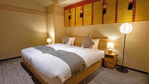 a bedroom with a large white bed and a lamp at Stay SAKURA Tokyo Asakusa Yokozuna Hotel in Tokyo