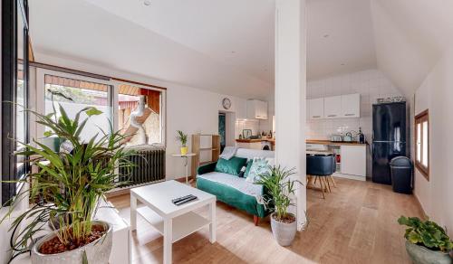 un salon avec un canapé et quelques plantes dans l'établissement Huge House 210sqm 19 people Private Outdoor 2 Parking Top Location, à Saint-Ouen