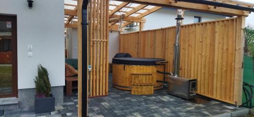 a patio with a wooden fence and a grill at Apartment house with sauna and jacuzzi Svätý Kríž 1 in Svätý Kríž