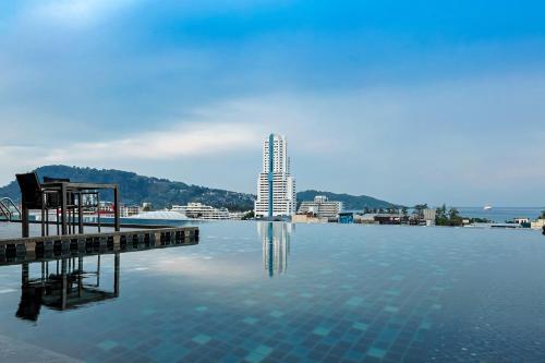 a large pool of water with a building in the background at The Gig Hotel in Patong Beach