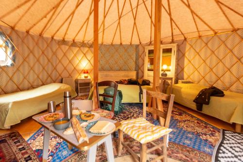 - une chambre avec une table et des chaises dans une yourte dans l'établissement Tentes canadienne - Camping des trois rivières, à Bassignac