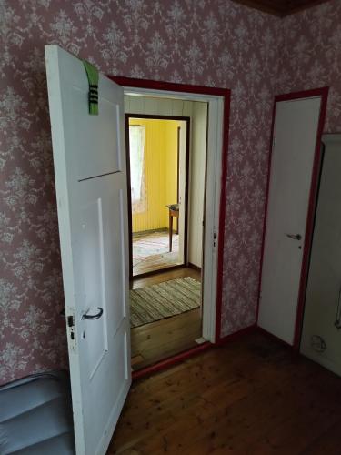 une porte ouverte menant à une chambre avec couloir dans l'établissement Topsala MidIsland, à Houtskari
