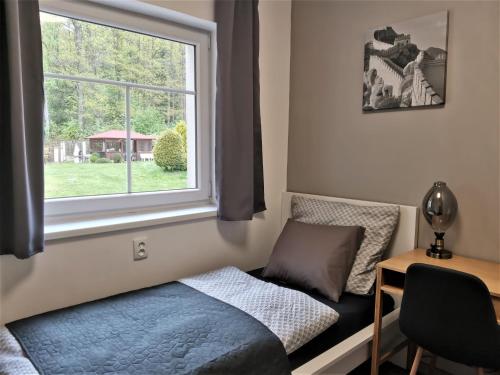a bedroom with a bed and a window at APARTMÁN POHODA in Svatava