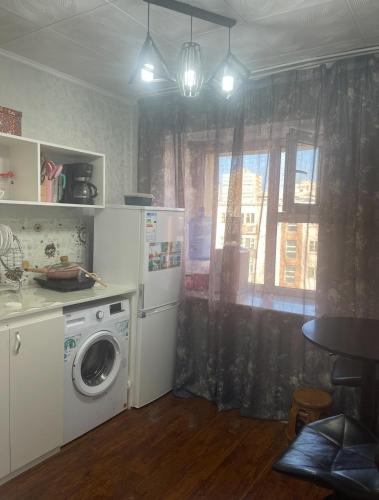 een keuken met een wasmachine en een raam bij Fully furnished 1 room apt in Ulaanbaatar