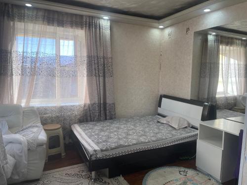 een kleine slaapkamer met een bed en een raam bij Fully furnished 1 room apt in Ulaanbaatar