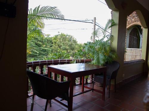 uma mesa de madeira e cadeiras numa varanda em Kep Villa Hill Guest House 1 em Kep