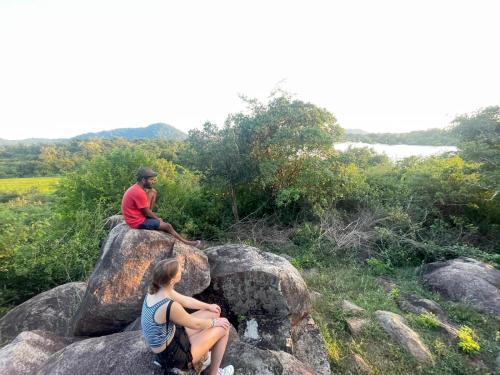 two people sitting on rocks on a mountain at Basecamp - Yala in Yala