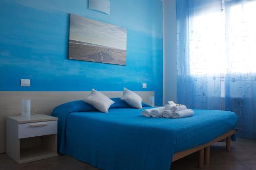 Un dormitorio azul con una cama con dos animales de peluche. en La Via Del Volano, en Codigoro