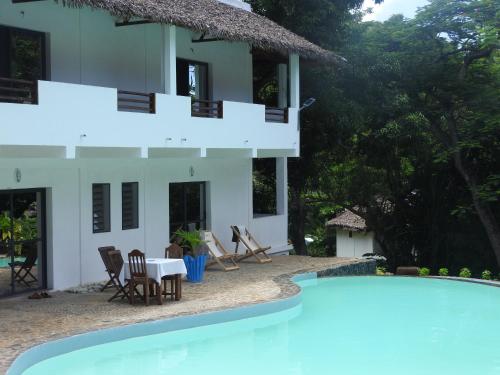 een villa met een zwembad en een huis bij Auberge SAKATI'Art in Nosy Be