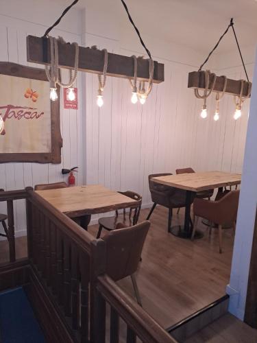 a restaurant with wooden tables and chairs and lights at Hotel Merino in Pas de la Casa
