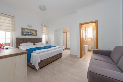 a bedroom with a bed and a couch at Luxury Villa Agape Palm Beach Tennisplatz in Privlaka