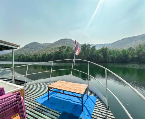 a table on the deck of a boat on a river at ชอว์ งาทอง รีสอร์ต Chor Ngar Thong Erawan Kanchanaburi in Kanchanaburi