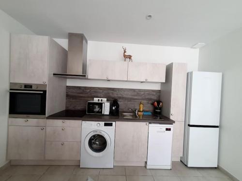 uma cozinha com uma máquina de lavar roupa e um frigorífico em Ax-les-Thermes Location appartement T2 38m2 em Ax-les-Thermes