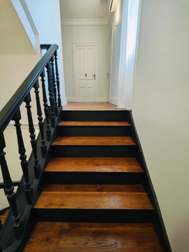 a stairway with black and wooden treads and a white door at Self-checkin house - Private rooms to rent in a beautiful town house - Not a hotel - Shared facilities - Extra fee for sheets and towels - Private parking - Check your plateform inbox and follow check-in instructions - Chambres privées - Arrivée autonome in Saint-Romain-en-Gal