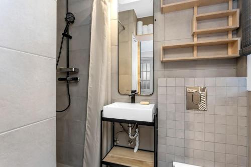 een badkamer met een witte wastafel en een spiegel bij Bright 1BR Apartment in Reykjavík in Reykjavík
