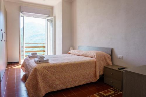 a bedroom with a bed and a large window at Albergo ristorante Payarin in Ormea