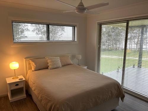 una camera con letto, ventilatore a soffitto e finestra di Four Bedroom Lake Side House Recent Reno a Rocky Point