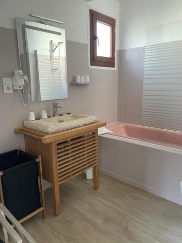 W łazience znajduje się umywalka i różowa wanna. w obiekcie Hôtel Saint Clair w Lourdes