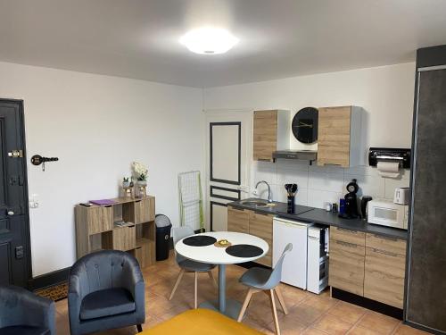 une cuisine avec une table et des chaises dans une pièce dans l'établissement Studio Yannick, à Vittel
