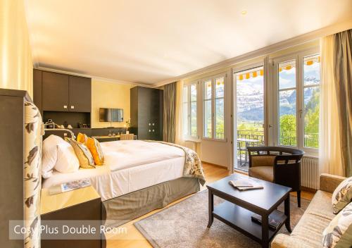 a bedroom with a bed and a living room at Lenkerhof gourmet spa resort - Relais & Châteaux in Lenk