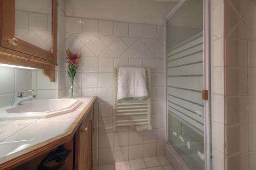 a white bathroom with a shower and a sink at Résidence Le Cristal Apartments in Chamonix-Mont-Blanc