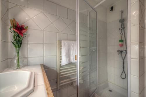 a bathroom with a shower and a vase with a red flower at Résidence Le Cristal Apartments in Chamonix-Mont-Blanc