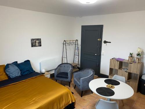 une chambre avec un lit, une table et des chaises dans l'établissement Studio Yannick, à Vittel