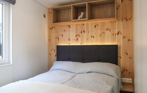 1 dormitorio con 1 cama con pared de madera en Tiny House Lohse, en Wemding